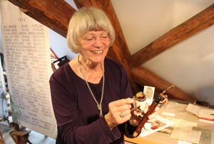 Erika Porten vom Heimatkreis mit einer Pfeife von vor 100 Jahren, die eine spielerische "Pickelhaube" hat