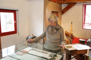 Erika Porten an der Vitrine mit alten Fotoaufnahmen von vor 60 Jahren