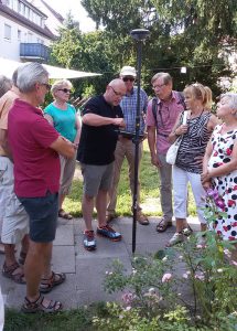 Besucher bei der Demonstration eines satellitengestützten Vermessungsinstruments im Pfarrgarten