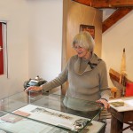 Erika Porten an der Vitrine mit alten Fotoaufnahmen von vor 60 Jahren