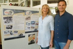 Mutter und Sohn Gellera vor dem Plakat von Julius Spiess und dessen Autohaus